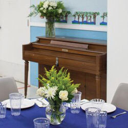 Dining room with upright piano and fresh flowers